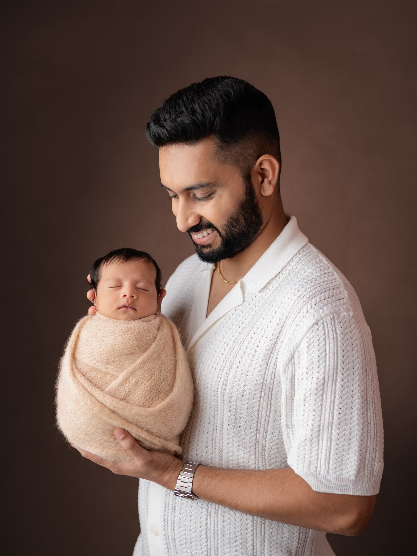 Father holding wrapped newborn